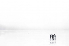 Men Ice Fishing on Frozen Lake