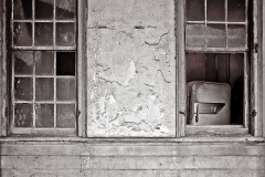 Refrigerator in window of abandoned house.