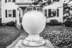 Eyeglasses on cement post outside a home.