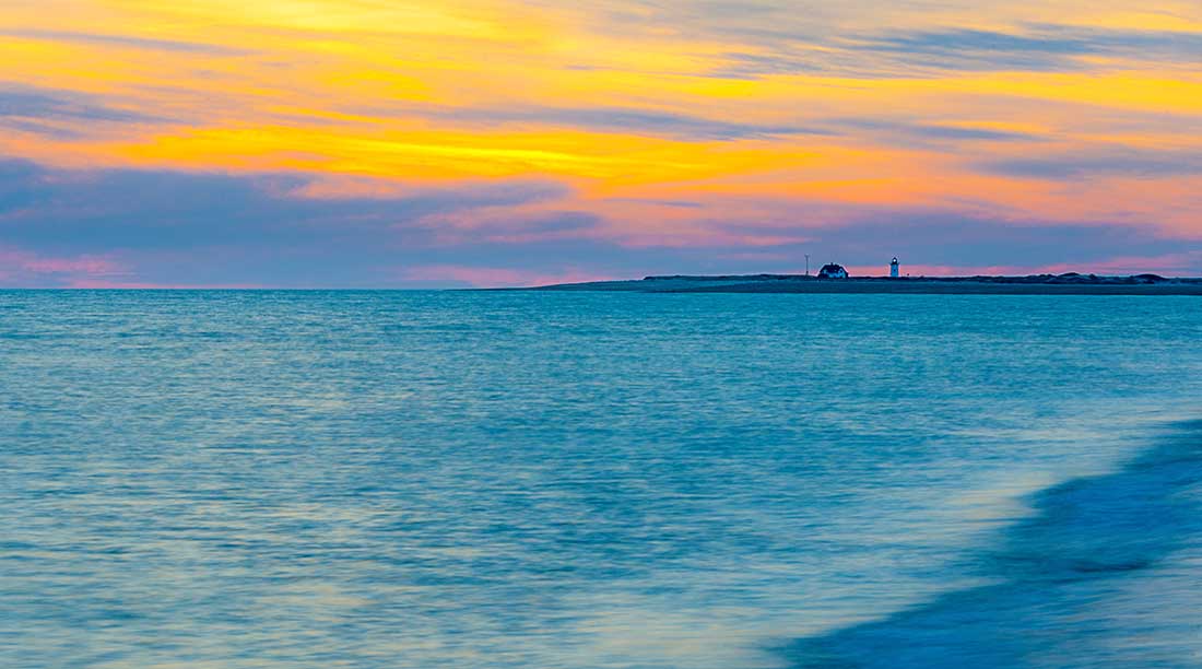 Sunset over lighthouse, Herring Cover Beach, Provincetown, Cape Cod.
