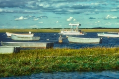 Fisherman pushing boat in Cape Cod Bay.