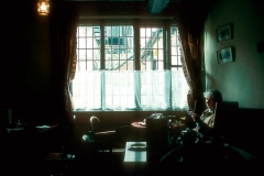Elderly woman sitting in a pub or restaurant.