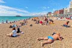 Sun bathers and swimmers relaxing on the ocean beach in Brighton, England.