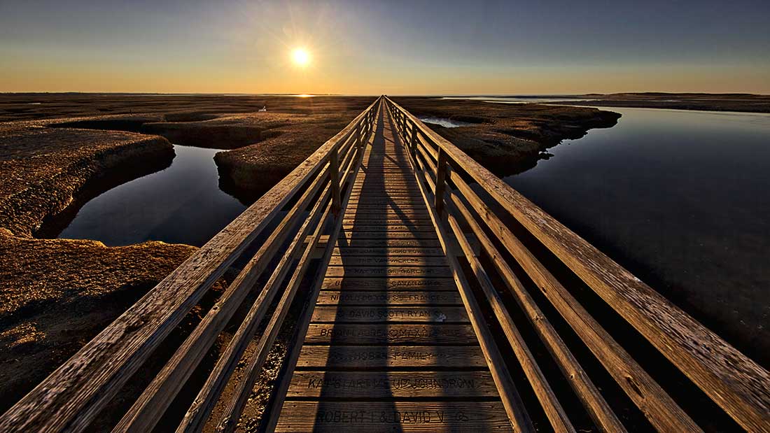 Sunset over the wooden walkway by Grays Beach in Yarmouth, Cape Cod, Massachusetts.