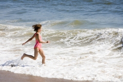 Young Girl running into the Ocean.