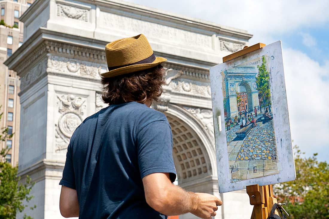 An artist works on his painting in Washington Square Park in Manhattan, New York City.