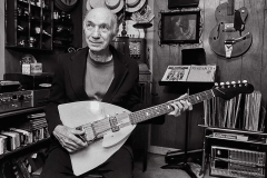 Retired man holding his guitar.